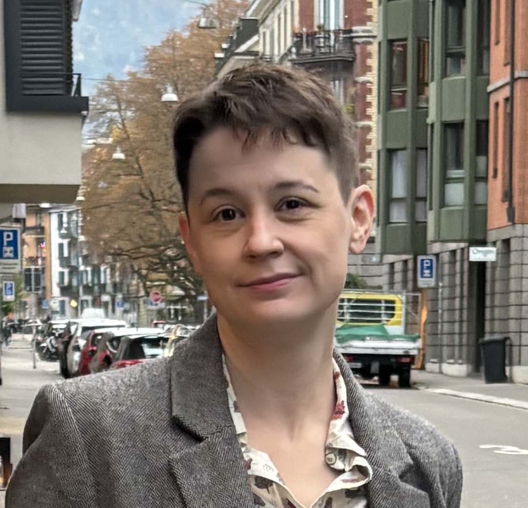 Marlowe, a white nonbinary person with short brown hair, wearing a tweed jacket.